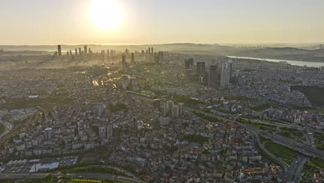 Istanbul-Turkey-Aerial-v34-breathtaking-sunrise-view,-panoramic-panning-across-beyoğlu-district-capturing-downtown-cityscape-with-big-bright-sun-glowing-in-the-sky---Shot-with-Mavic-3-Cine---July-2022