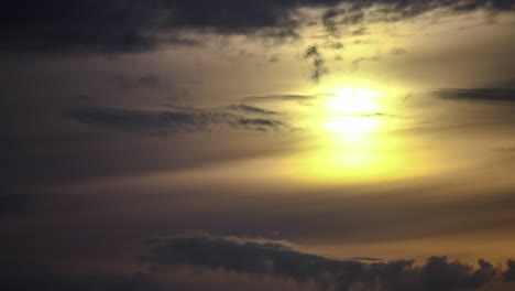 Atemberaubende-Sonnenaufgangslandschaft-Mit-Warmer-Sonne,-Die-Durch-Graue-Wolken-Am-Himmel-Aufgeht