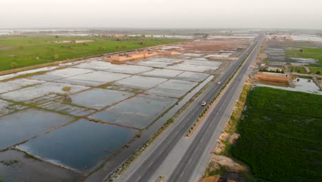 Aerial-View-Of-Highway-Cutting-Through-Rural-Jacobabad-With-Water-Logged-Fields-On-Left-Hand-Side