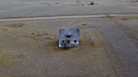 Aerial-view-of-an-old-torn-up-abandoned-house-in-the-country-near-Empress-Alberta-Canada-during-the-day