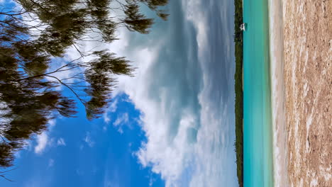 Vertical-format-timelapse-of-anchored-boat-in-beautiful-Kuto-Bay,-Isle-of-Pines