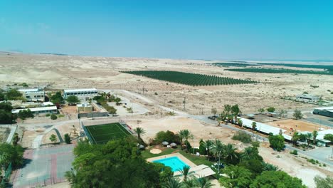 Drone-shot-of-a-kibbutz-and-a-palm-tree-field-in-the-desert