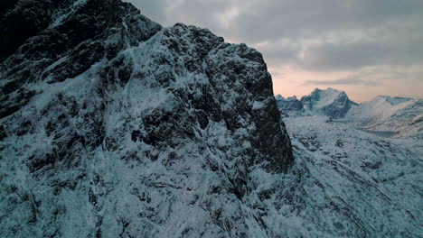 Snow-covered-jagged-Lofoten-mountain-peaks-aerial-view-across-the-summit-at-sunrise
