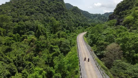 Drone-follow-motorbikes-on-the-road-deep-in-jungle