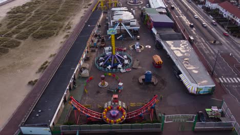 Children's-amusement-park-beside-highway-at-Great-Yarmouth,-Norfolk---aerial-drone-shot