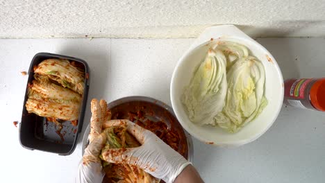 Blick-Von-Oben-Nach-Unten-Auf-Männliche-Hände,-Die-Kimchi-Kohl-Zubereiten-Und-Verpacken