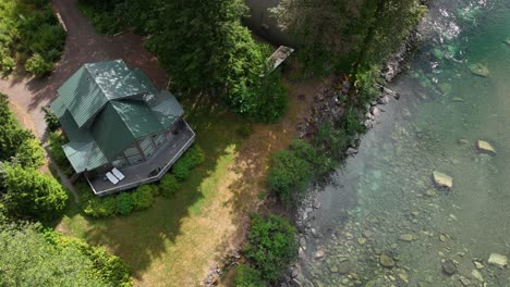 Top-down-aerial-view-of-a-cabin-with-the-Skykomish-River-flowing-right-next-to-it
