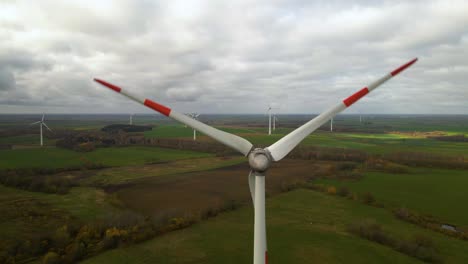 Aerial-shot-of-multiple-rotating-wind-turbines-for-renewable-electric-power-production-in-a-wide-rural-area