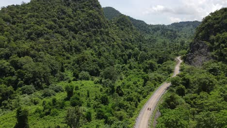Drone-moves-upward-from-road-to-reveal-vast-jungle-and-mountain