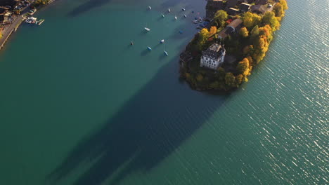 Cinematic-downward-angle-drone-shot-of-the-Iseltwald-Castle-on-Lake-Brienz-in-Switzerland