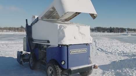 Zamboni-ice-resurfacer-opening-lid-to-dump-snow-out