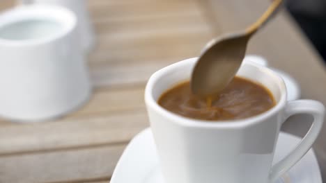 Hand-Fügt-Löffel-Zucker-In-Tasse-Kaffee-Hinzu