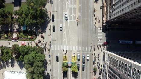 Corner-of-Michigan-Avenue-and-Monroe-Street-in-downtown-Chicago,-Illinois-with-drone-video-overhead-showing-traffic-and-pedestrians