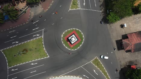 Aerial-top-down-view-spinning-over-busy-roundabout-with-tuk-tuks,-rickshaws-and-cars-driving-by-in-Galle,-Sri-Lanka