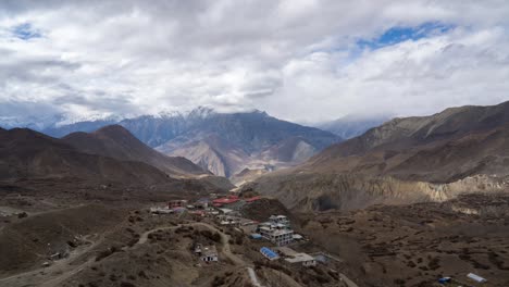 Ein-Zeitraffervideo-Von-Wolken,-Die-Sich-über-Die-Schroffen-Himalaya-berge-Bewegen,-Mit-Der-Stadt-Muktinath-Im-Vordergrund
