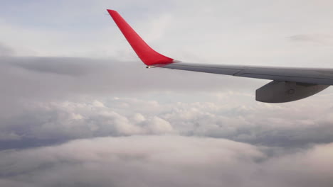 Low-cost-airplane-wing-flying-through-sea-clouds