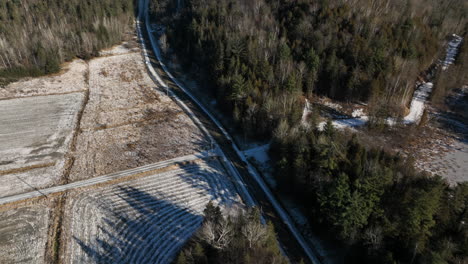 Drone-Flyover-Remote-Road-With-Dense-Forest-During-Winter