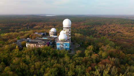 Calm-aerial-view-flight-drop-down-drone-of-Radom-Listening-station-in
autumn-forest-at-morning-sunrise,-devil's-mountain-in-woods-berlin-October-2022