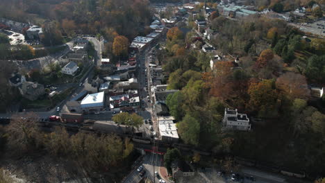 Historic-Ellicott-City-and-Freight-Train-on-Old-Railroad,-Drone-Aerial-View-on-Sunny-Autumn-Day,-Maryland-USA