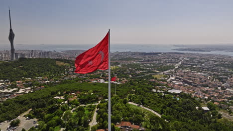 Istanbul-Turkey-Aerial-v80-panoramic-view-drone-fly-around-waving-national-flag-at-camlica-hill-capturing-downtown-cityscape,-bosphorus-strait-and-famous-landmarks---Shot-with-Mavic-3-Cine---July-2022