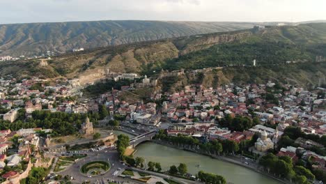 Majestic-city-of-Tbilisi-with-river-in-middle,-aerial-drone-view