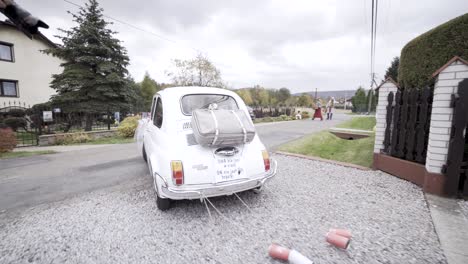 wedding-white-old-car-with-cans-leaving-the-home-road