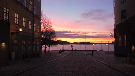 Panning-across-colorful-sunset-during-dawn-shot-from-Gamla-Stan-old-town-in-Stockholm,-Sweden