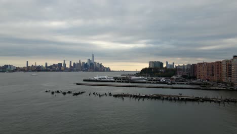 Aerial-drone-view-over-docks-in-Jersey-city-towards-lower-Manhattan,-in-gloomy-New-York
