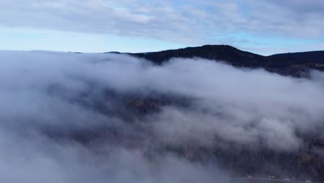 Stimmungsvoller,-Dunkler-Luftwald-In-Wolken,-Der-Die-Bergspitze-Enthüllt