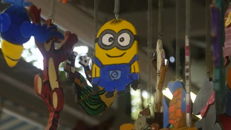 The-figure-of-a-Minion-made-of-wood-hangs-on-the-ceiling-between-other-figures