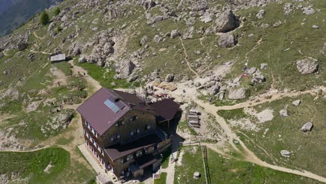 Aerial-view-showing-Mountain-Hut-at-Roda-di-Vael-during-sunny-day-with-hiking-people
