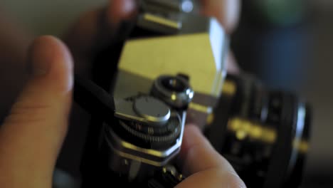 Man-uses-advance-lever-on-a-vintage-35mm-camera-and-takes-a-photo
