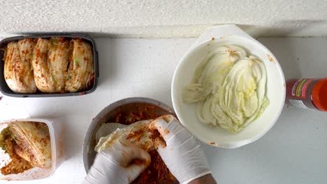 Männliche-Hände-Mit-Handschuhen,-Die-Hausgemachtes-Koreanisches-Kimchi-In-Der-Küche-Zubereiten