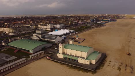 Sea-side-Amusement-Arcade-buildings-with-city-view-at-Great-Yarmouth,-Norfolk---aerial-ascending-drone-shot