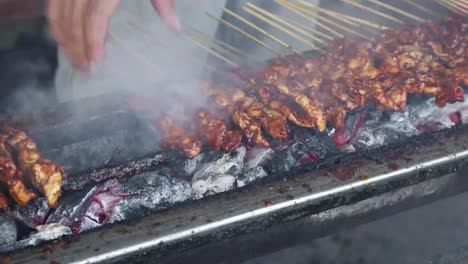 Street-food-vendor-grilling-satay,-grilled-meat-on-skewer