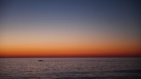 Boat-on-Mediterranean-Sea-with-Beautiful-Vibrant-Sunset-on-the-Horizon