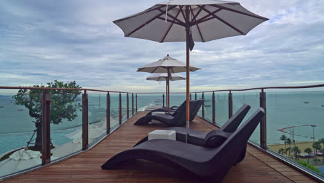 bed-pool-with-umbrella-around-swimming-pool-with-sea-background---holidays-and-vacation-concept