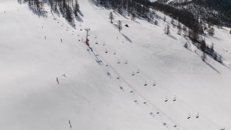 Skiers-skiing-the-slope-in-winter-aerial-view-captured-by-drone