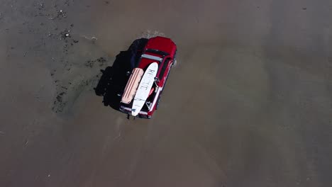 following-a-red-lifeguard-truck-from-the-air-driving-through-a-puddle