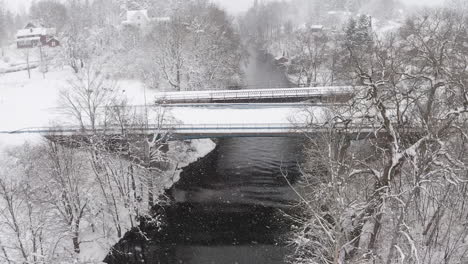 Vista-Aérea-De-Un-Puente-Cubierto-De-Nieve-Sobre-Un-Río-En-Un-Día-De-Invierno-En-Suecia