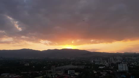 Sunset-in-Mexico-City-close-to-National-University,-with-an-airplane-cruising-the-sky