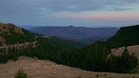 Aerial-revealing-shot-of-beautiful-forest-landscape-and-Dichiu-Mountains-in-Romania-during-evening