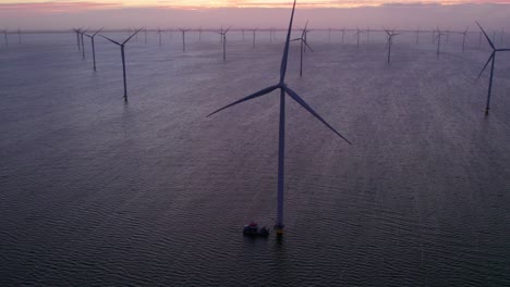 Early-morning-at-rotating-wind-turbines-at-Dutch-IJsselmeer-lake,-aerial