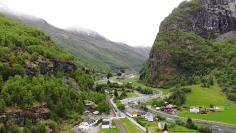 Aerial:-flying-over-the-Flåm-valley-among-mountains,-rivers-and-green-meadows