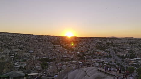 Göreme-Turkey-Aerial-v30-low-flyover-panoramic-sunset-view-point-on-high-plateau-across-ancient-village-town-capturing-golden-glowing-sun-setting-at-the-horizon---Shot-with-Mavic-3-Cine---July-2022