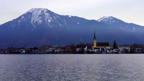 background-view-of-stunning-snow-capped-mountains-with-a-church-across-the-waters-of-Tegernsee