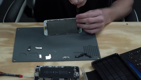 Man-repairing-iPhone-screen-and-replace-screws