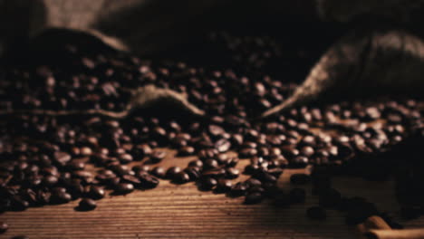 Camera-moving-away-and-focusing-on-a-bag-with-freshly-roasted-coffee-beans-on-a-wooden-table