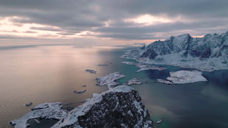Aerial-view-over-peaceful-frozen-Ramberg-glacial-mountain-peaks-overlooking-Norland-sunset-seascape