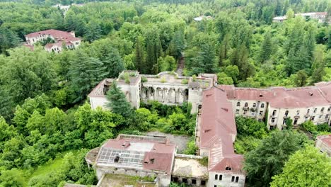 Massive-derelict-Sanatorium-building-in-Georgia,-aerial-fly-toward-view
